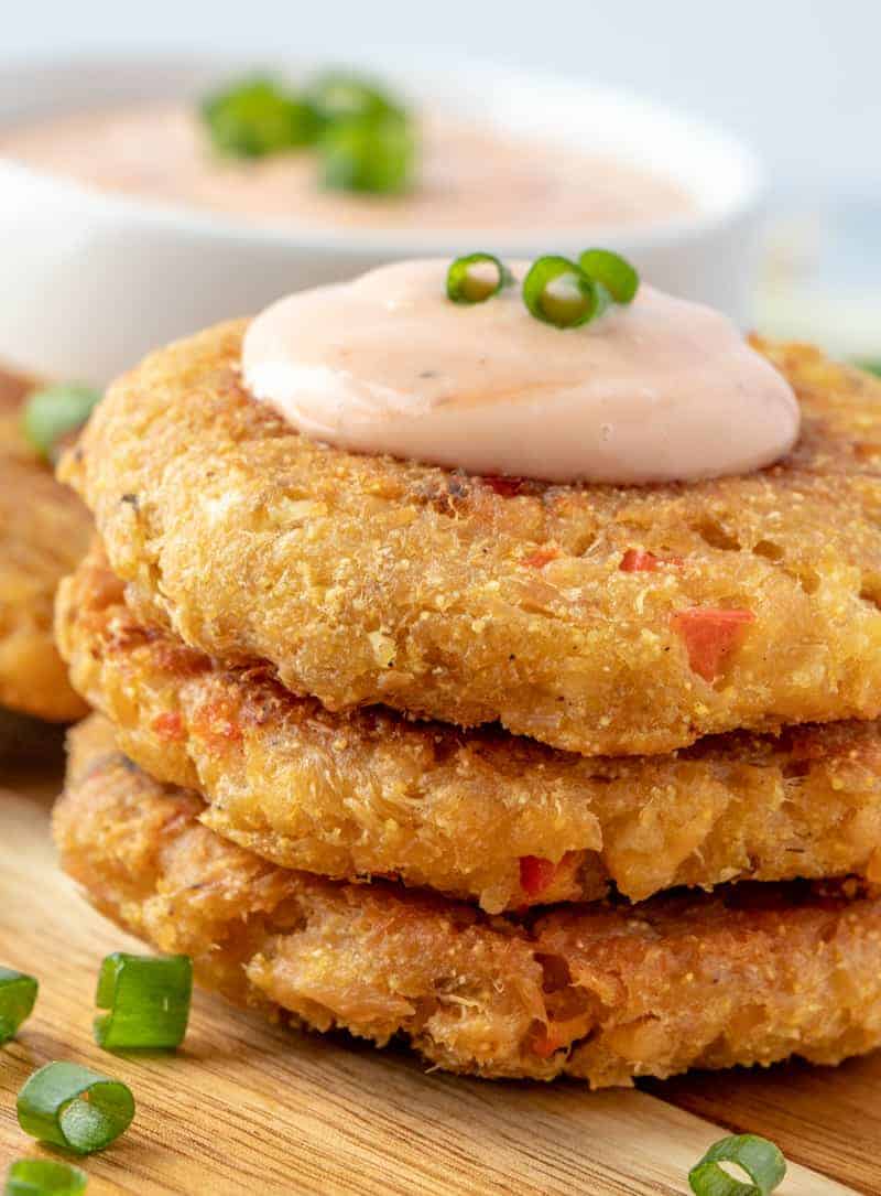 Salmon patties stacked with sauce on top