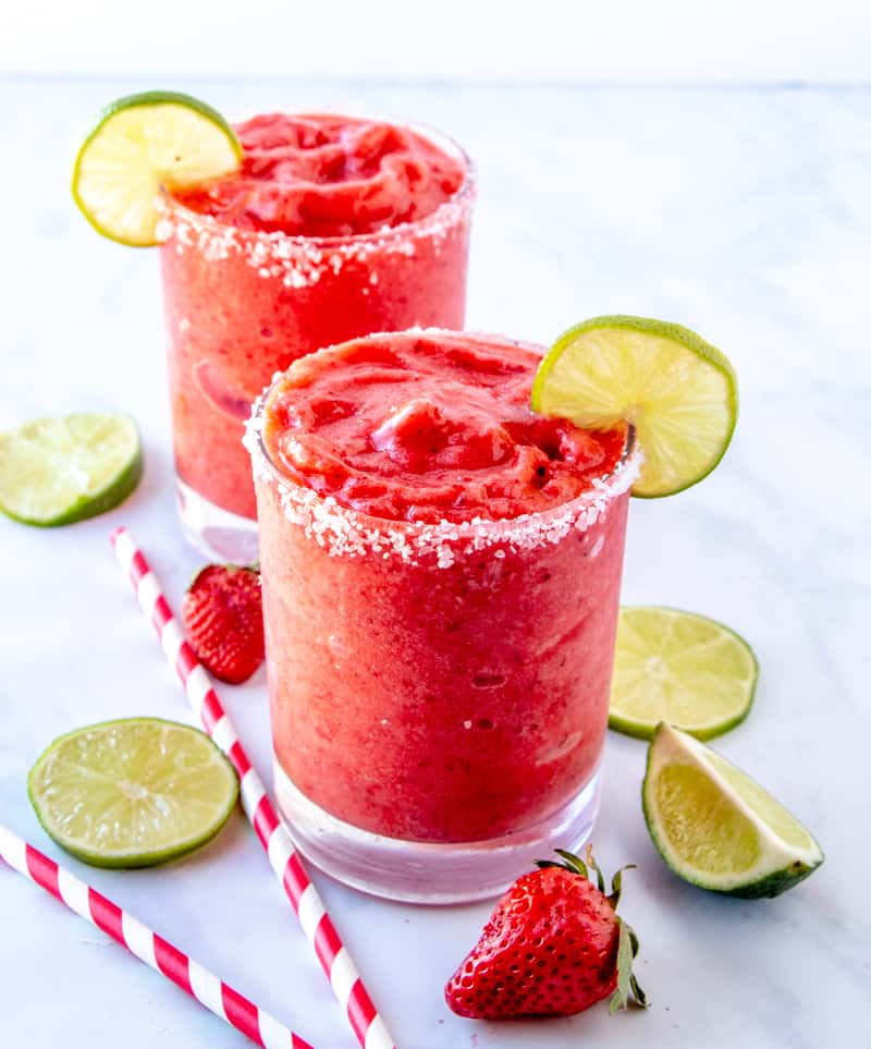 Two Glasses of Strawberry Margaritas with lime slices