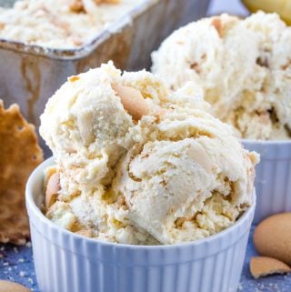 Scoops of banana ice creme in bowl with crushed and whole vanilla wafers surrounding it