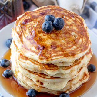Stacked Blueberry Pancakes dripping in syrup