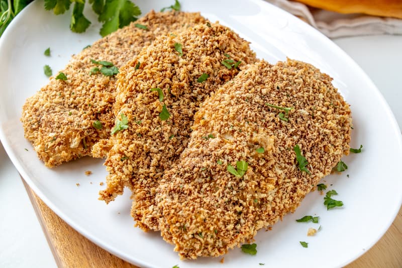 Baked Breaded Chicken on white plate horizontal photo layered