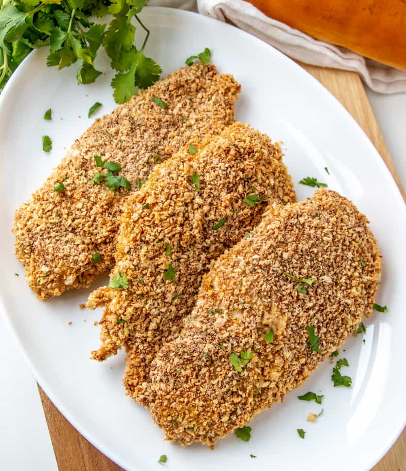 Baked Breaded Chicken on white plate overhead photo