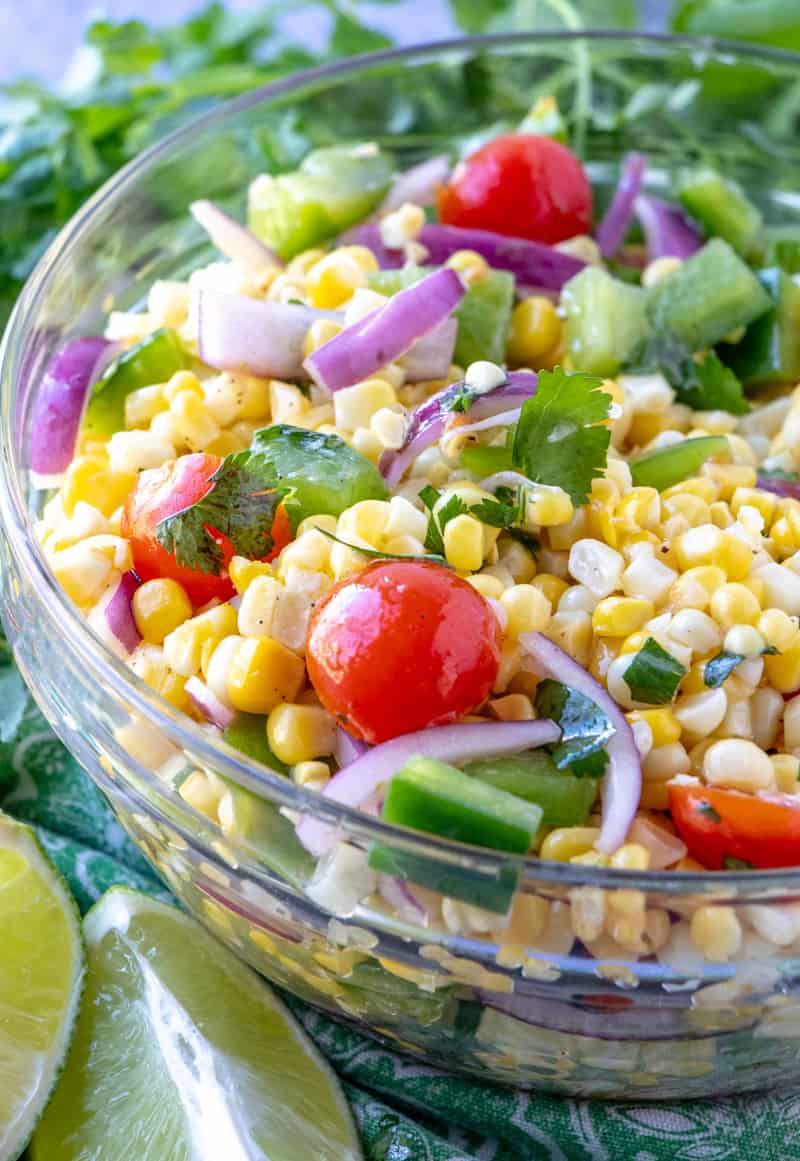 Corn salad in bowl with lime wedges next to it