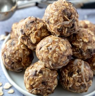 Stacked bites on white plate surrounded by oats and mini chocolate chips