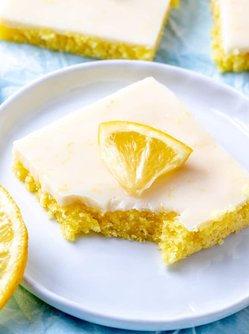 Bite taken out of Cake Mix Lemon Squares on white plate