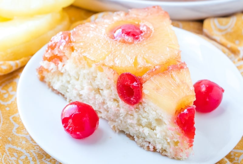 Horizontal photo of Pineapple Upside Down Cake recipe on plate with cherries