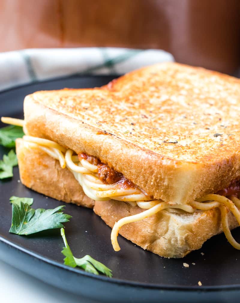 Spaghetti sandwich on black plate uncut