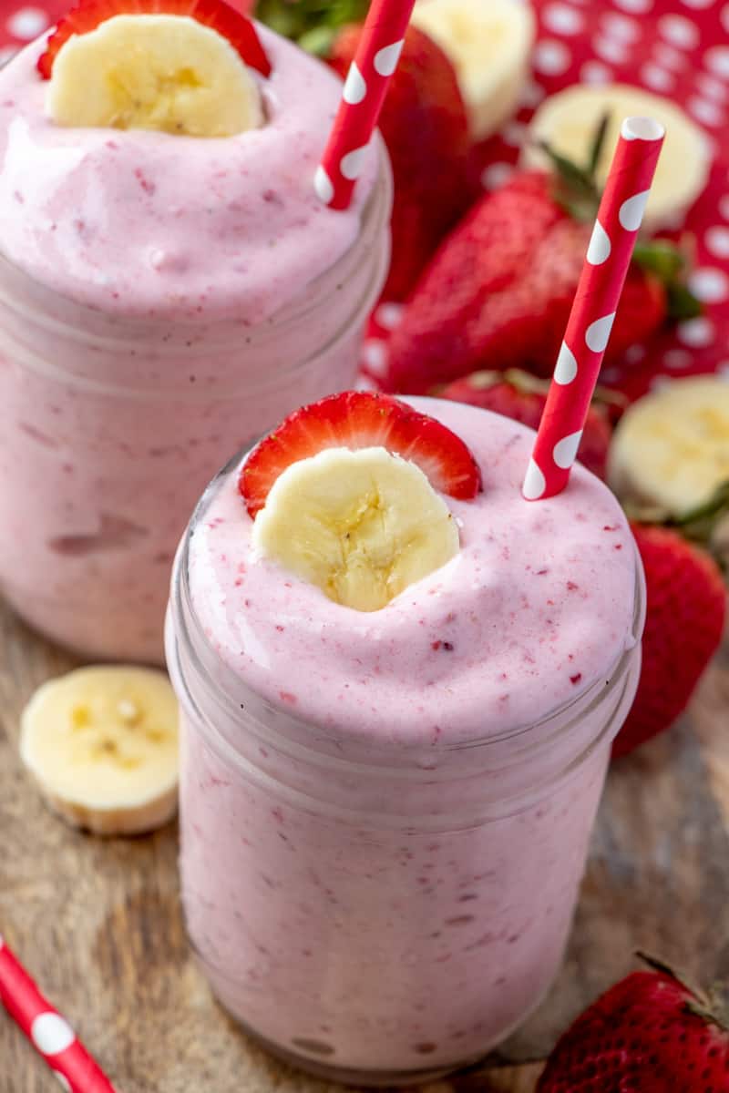 Overhead of smoothies topped with banana and strawberry