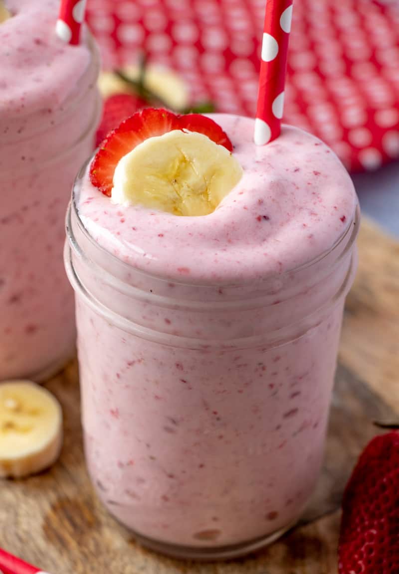 Jar full of Smoothie topped with sliced banana and strawberry