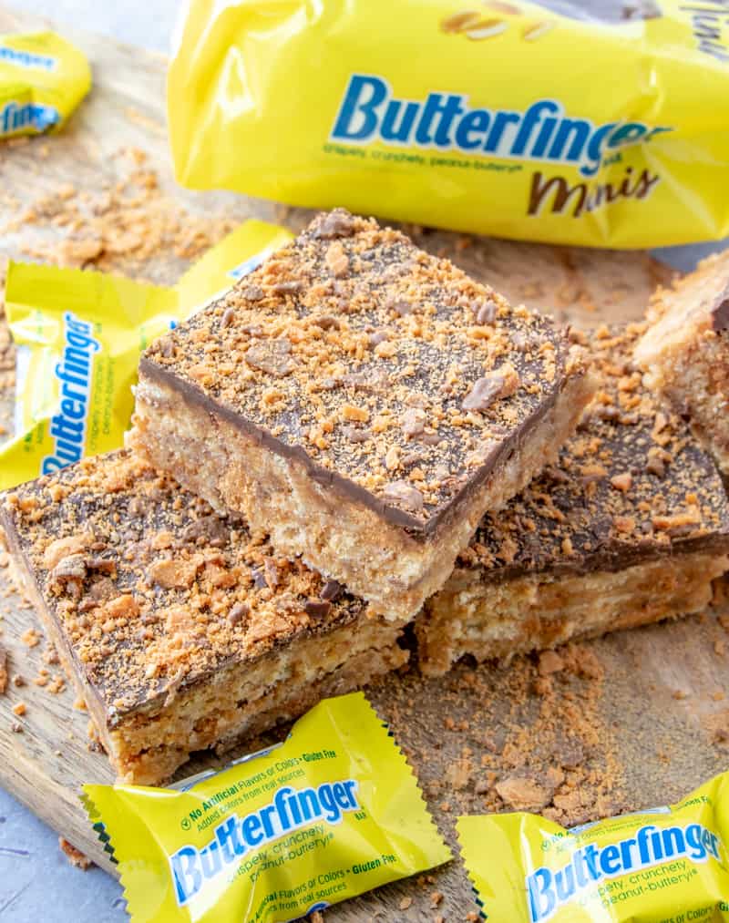 Butterfinger squares laid on top of one another on cutting board