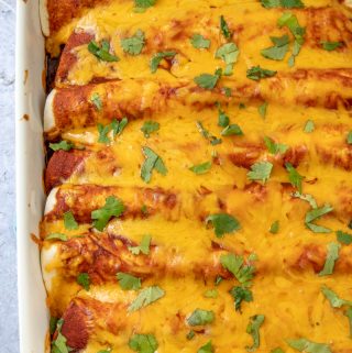 Finished beef enchiladas in baking pan toped with chopped cilantro