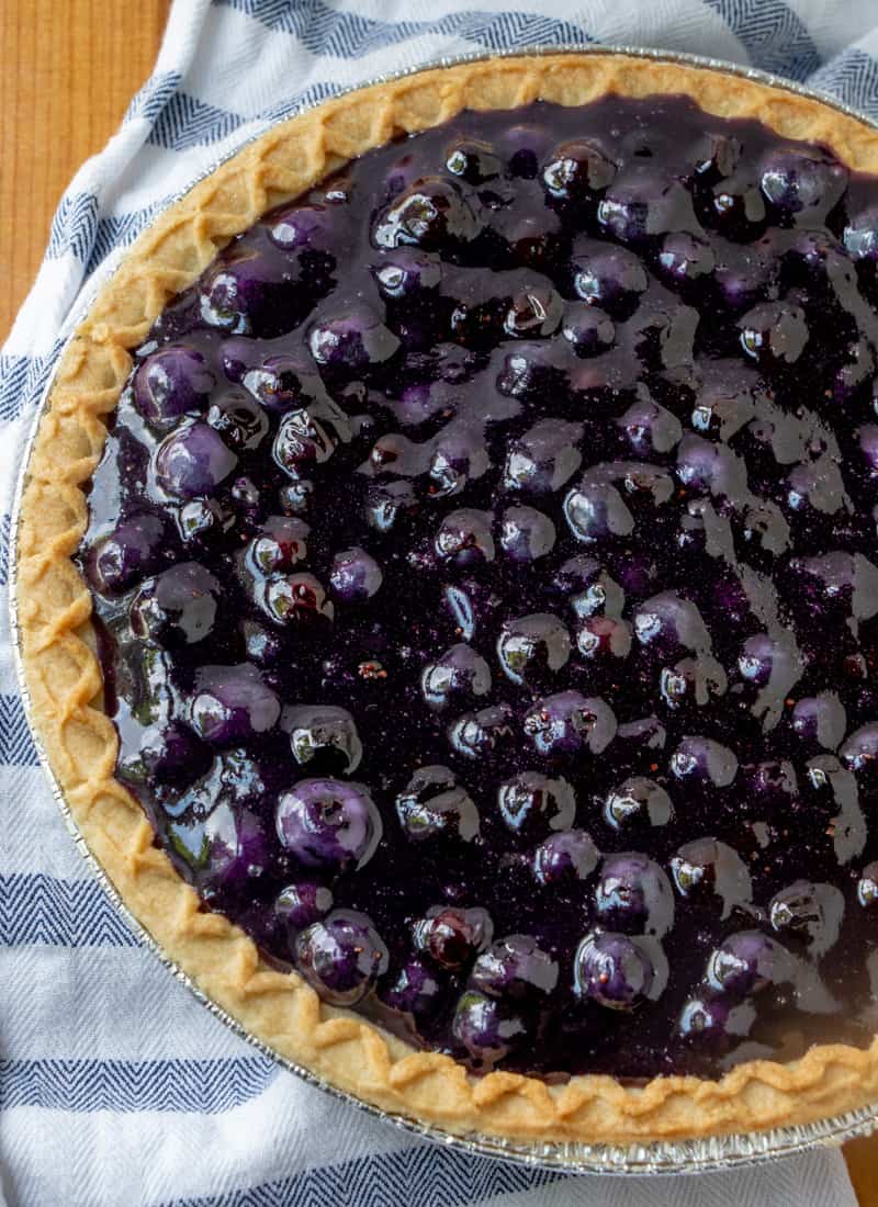 Overhead photo of finished pie with blueberries peaking out of top