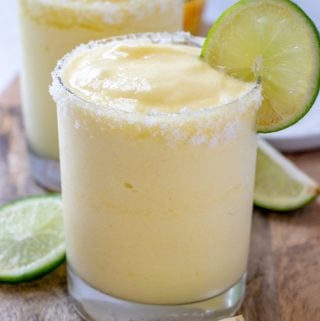 Pineapple Margaritas in clear glass rimmed with salt and garnished with lime slice