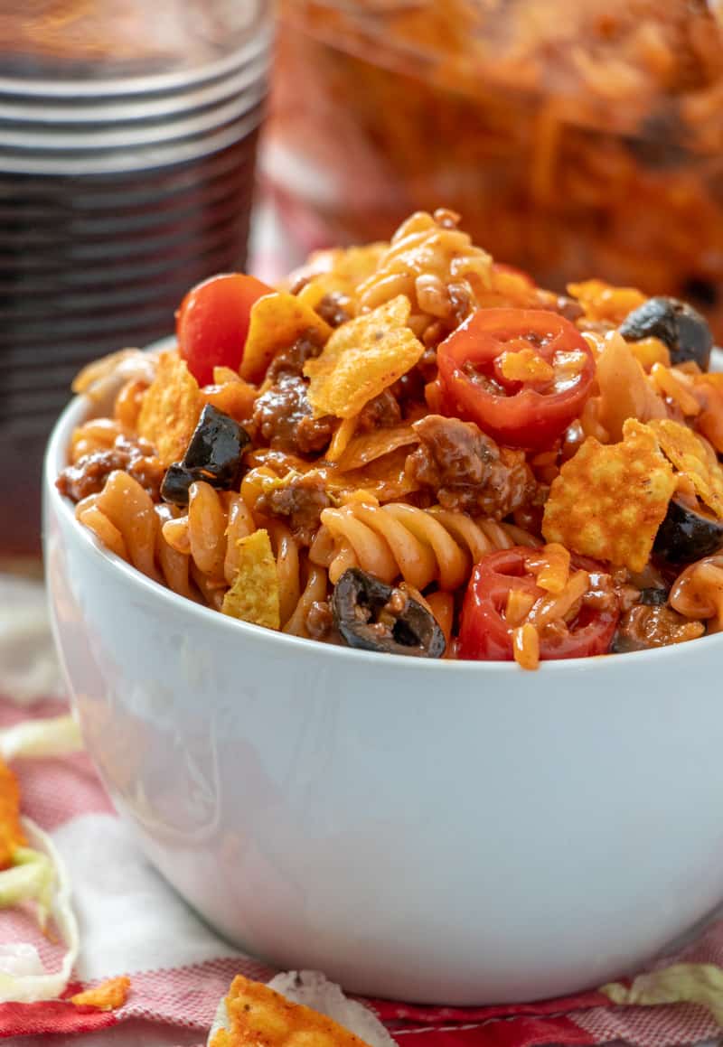 Taco pasta salad side photo with chips and lettuce lining the bowl