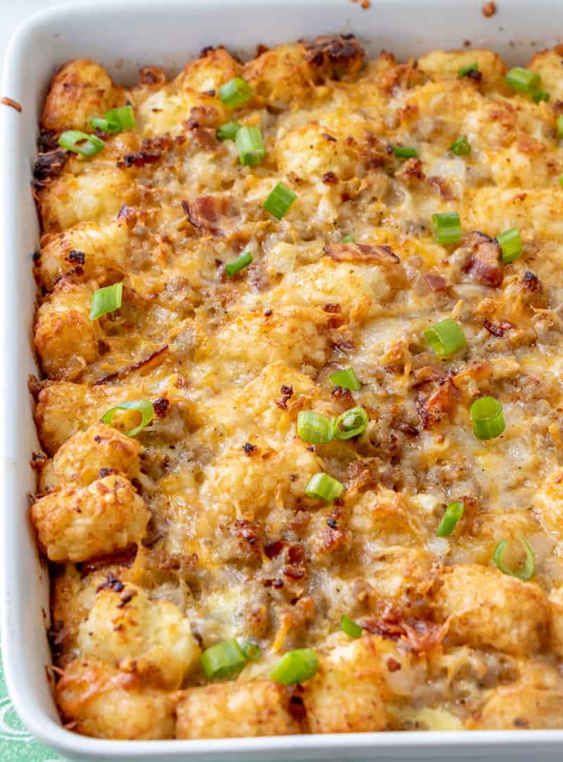 baked casserole in white dish with melted cheese bacon and green onions on top