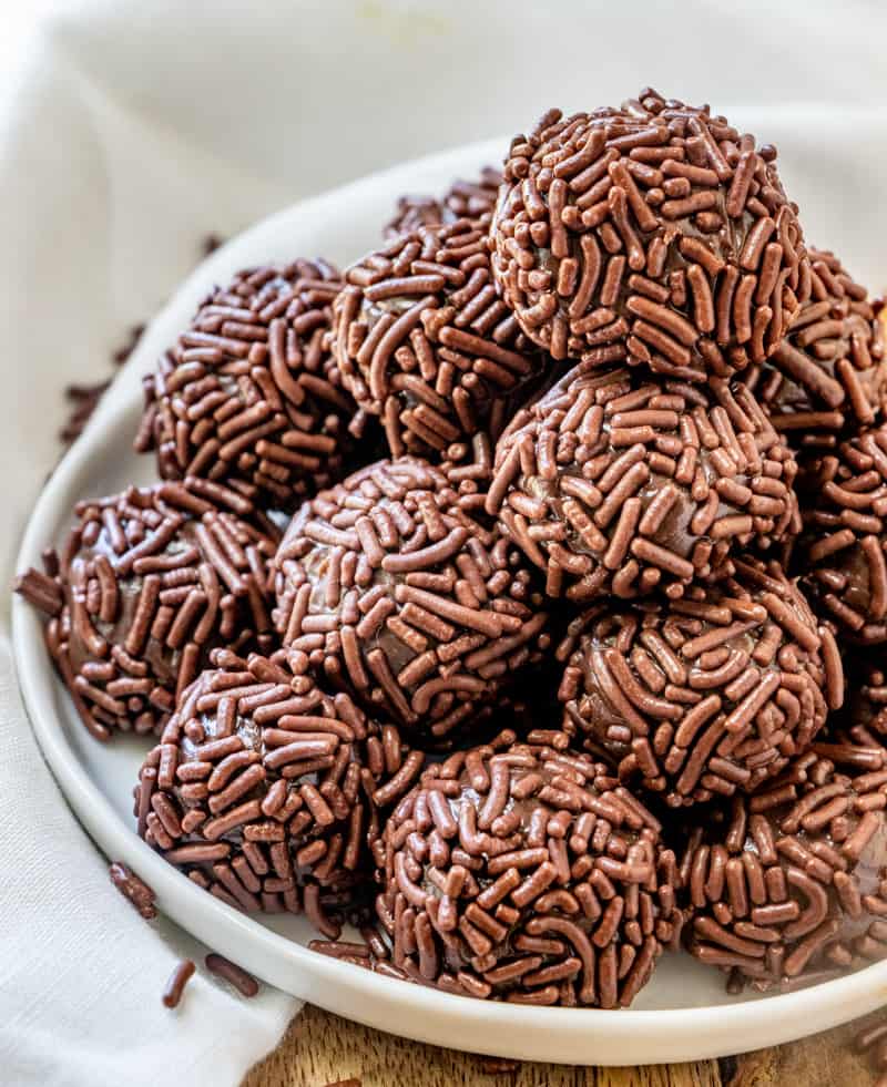 brigadeiros stacked on plate rolled in chocolate sprinkles