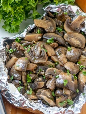 Finished Grilled Mushrooms with foil pack open sprinkled with chopped parsley