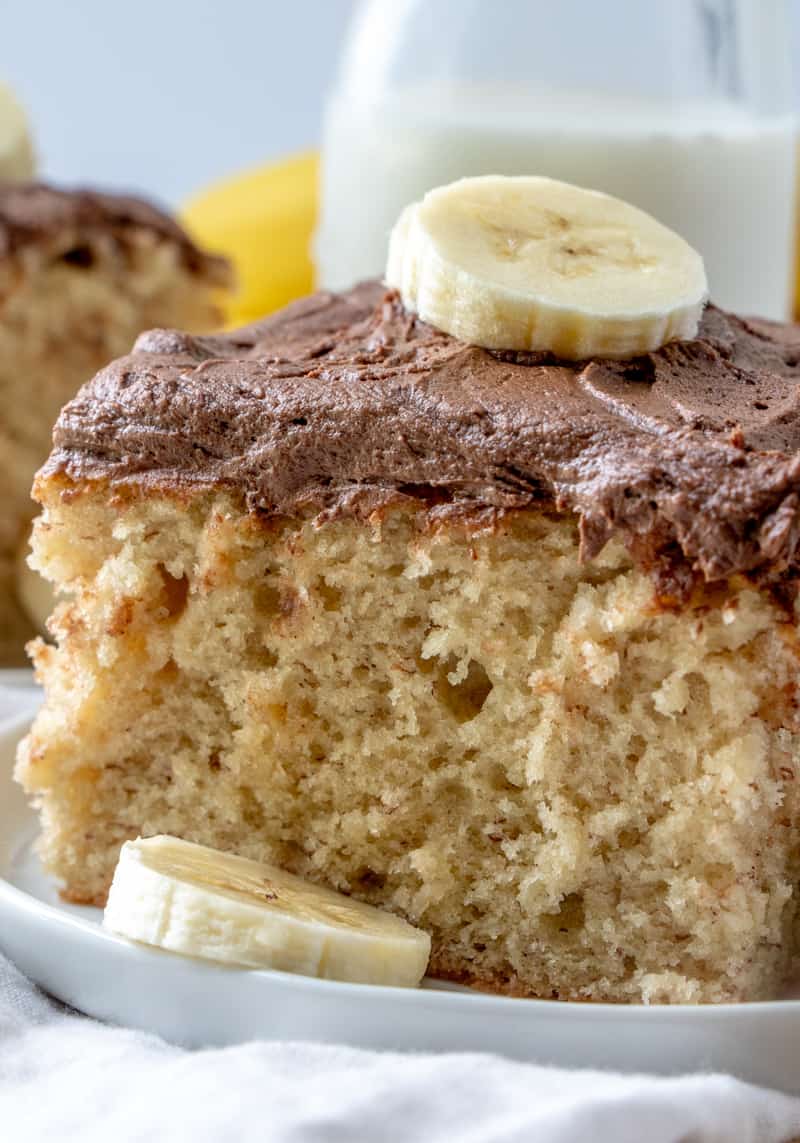 Slice of Easy Banana Cake on plate with sliced banana on top