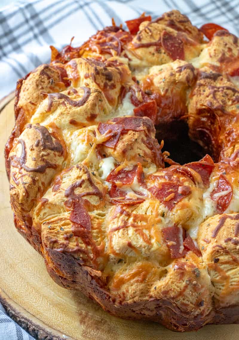Pizza Monkey Bread on serving board with melted golden cheese and pepperoni