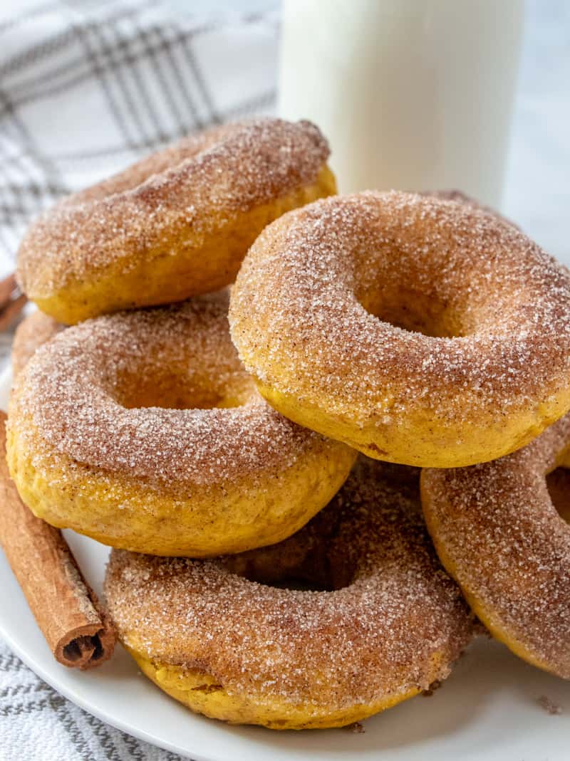 Pumpkin Donuts stacked on plate with cinnamon sugar topping