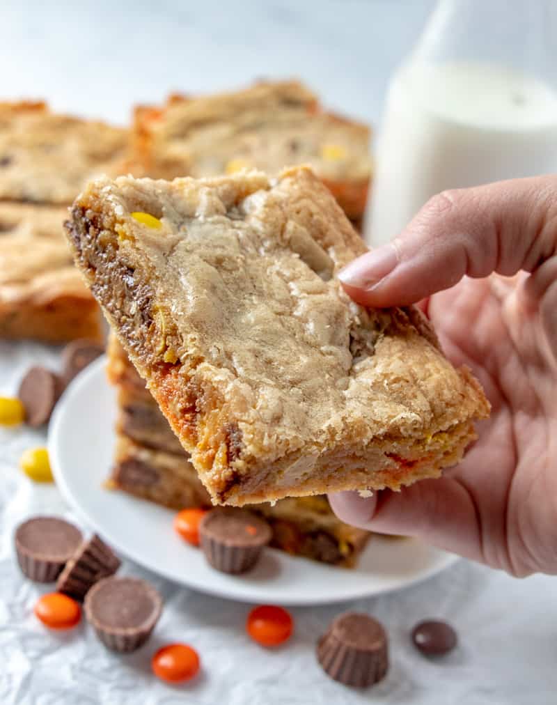 Hand holding peanut butter bar, gooey chocolate melting in the center