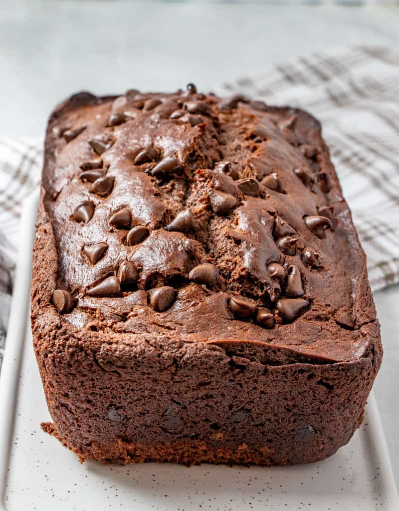 Chocolate Banana bread on serving tray baked and studded with chocolate chips on top