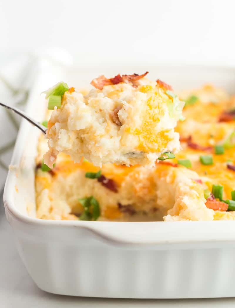 Mashed Potato Casserole scooped out on spoon in casserole