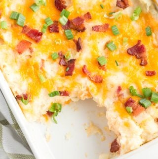 Overhead of cheese bacon topped casserole with a spoonful missing