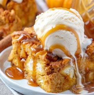 Plated bread pudding topped with ice cream and caramel sauce
