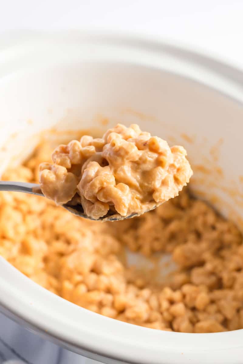 Creamy Slow Cooker Mac and Cheese on serving spoon coming out of slow cooker