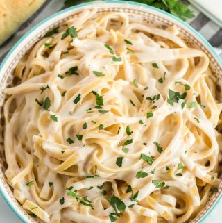 overhead of pasta in Alfredo sauce topped with parsley