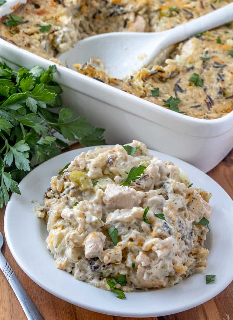 Chicken Wild Rice Casserole on plate with serving spoon in casserole dish in background