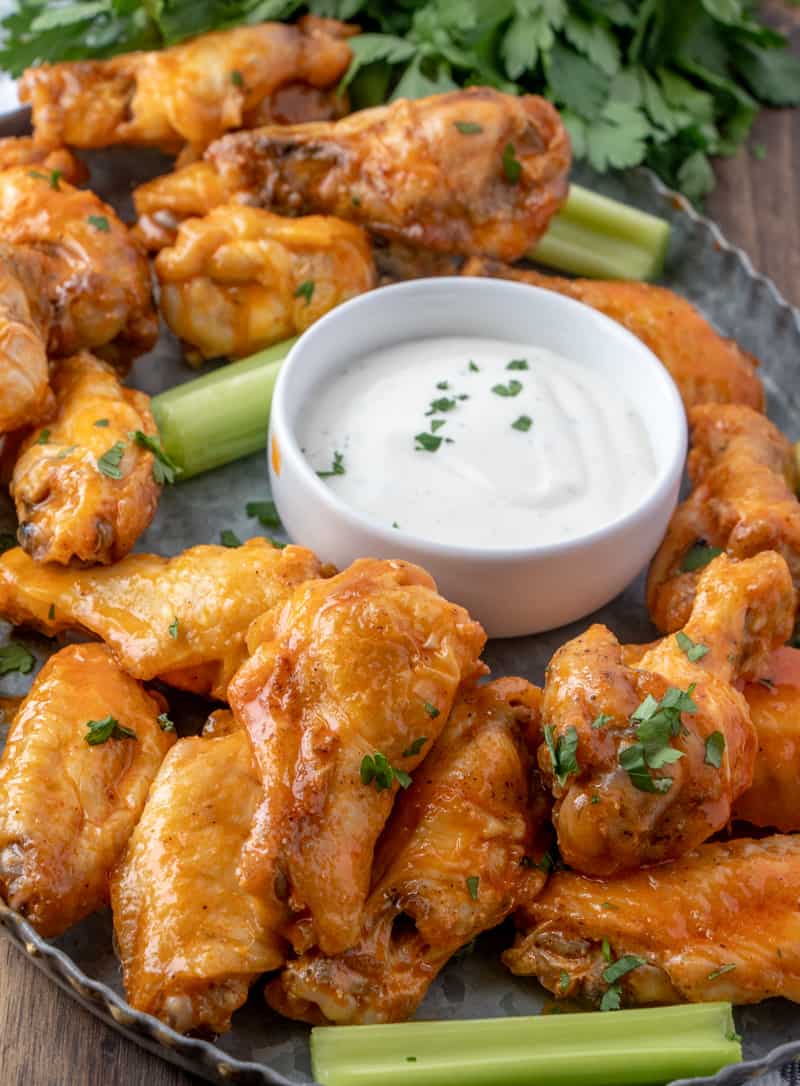 Baked Buffalo Wings on metal tray with celery and ranch