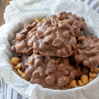 stacked peanut clusters in bowl with some peanuts to garnish