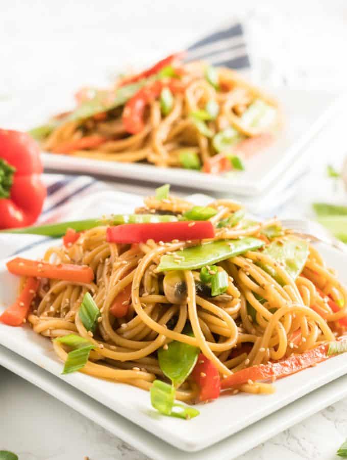 Lo mein plated showing vegetables and topped with sesame seeds