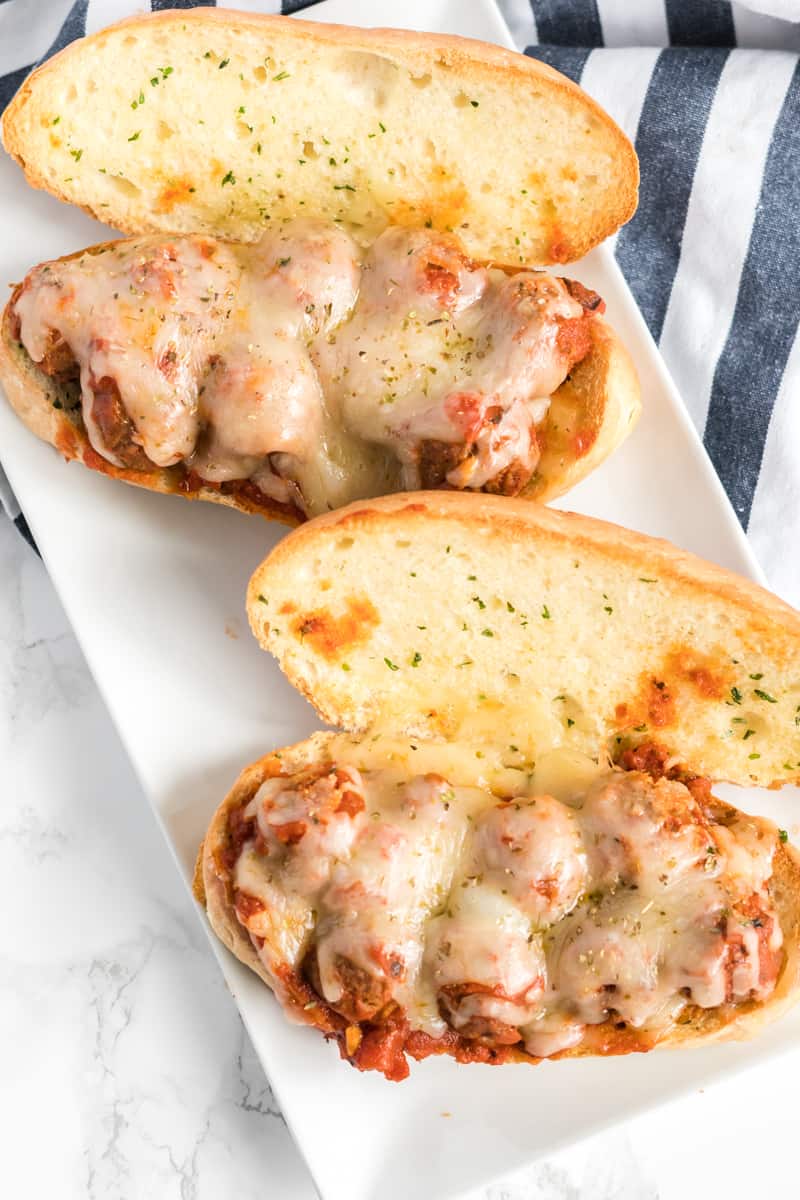 Overhead photo of assembled meatball subs sprinkled with oregano
