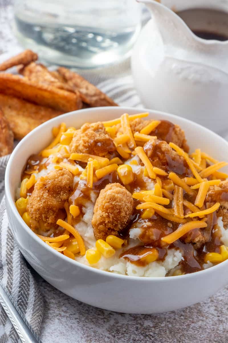 KFC Bowl with potato wedges in background and a gravy spout