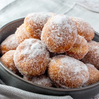 whole plate full of fried Chinese donuts covered in sugar