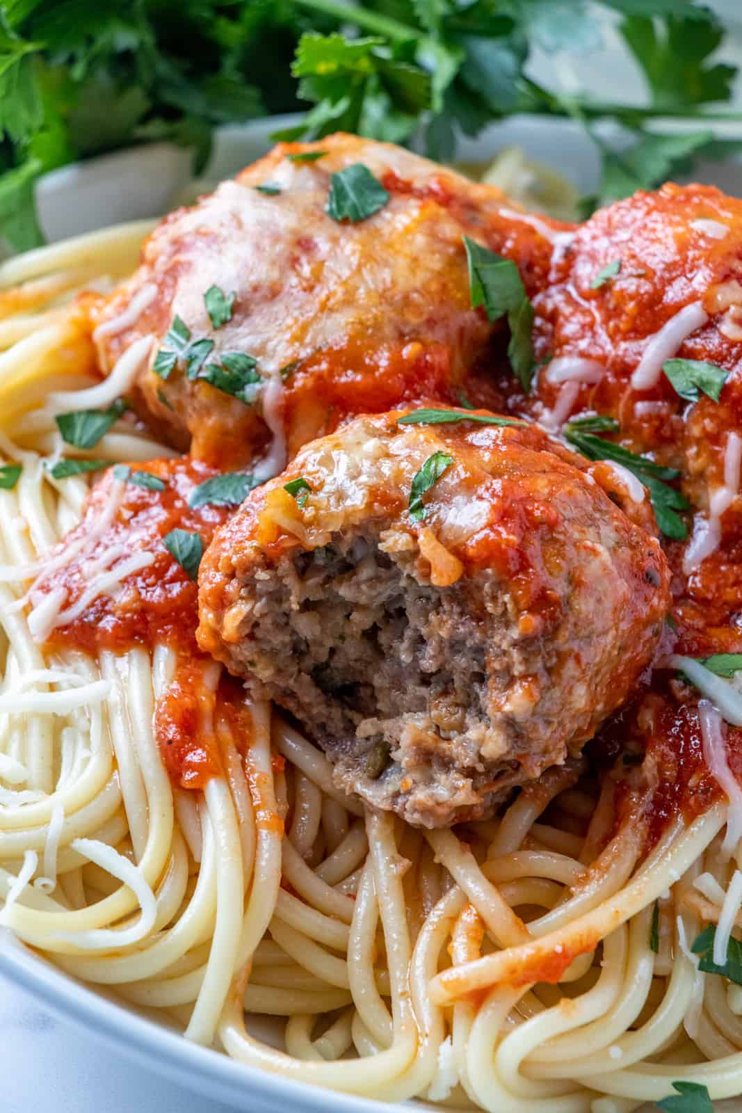 Close up photo of a bite taken out of one meatball