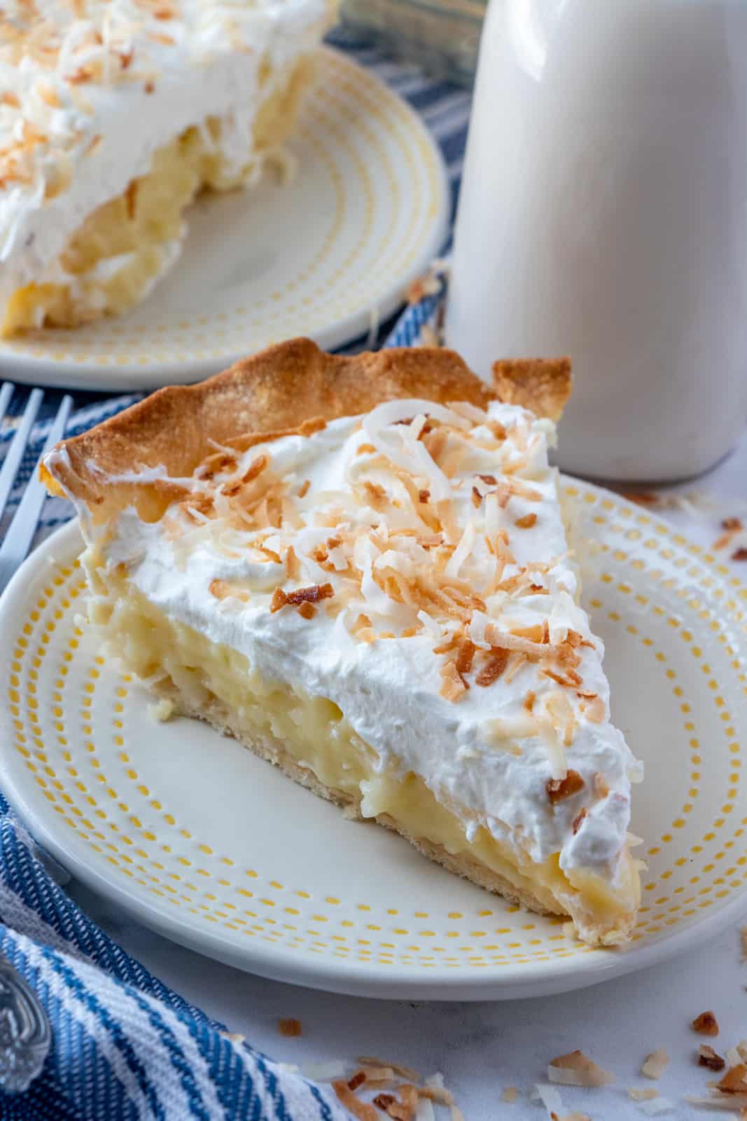 Slice of pie on plate topped with toasted coconut