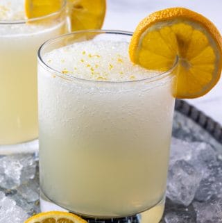 lemonade in glass surrounded by ice and garnished with lemon