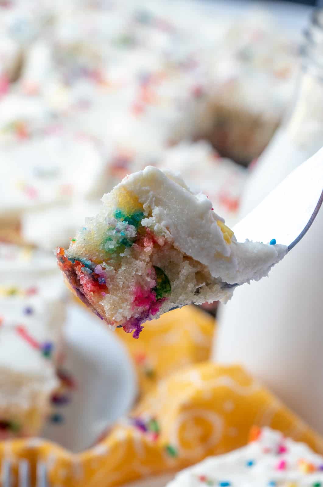 Fork holding a bite out of Funfetti cake