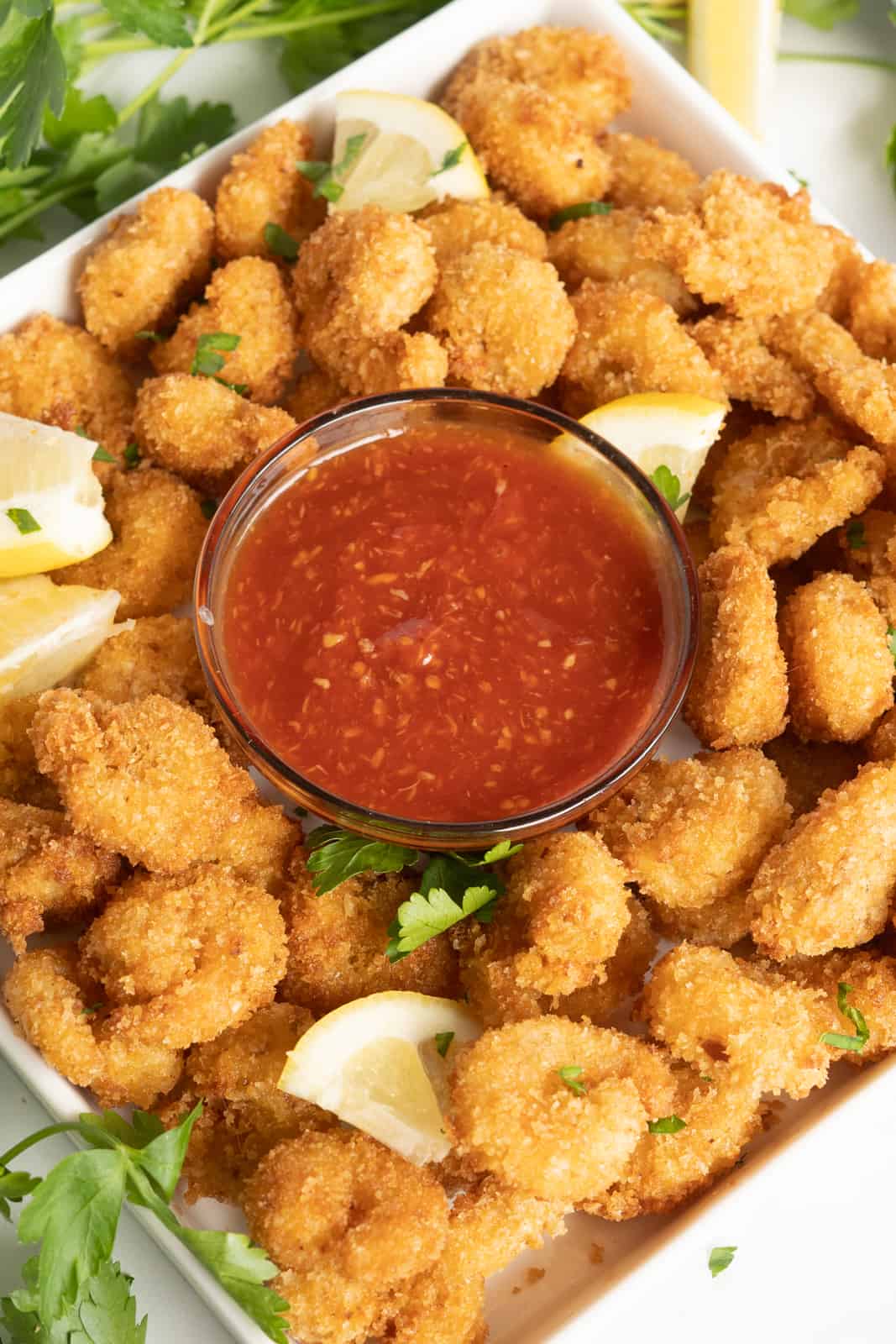 Overhead photo of Fried Shrimp on square plate with bowl of cocktail sauce in middle