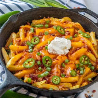 Finished and dressed loaded cheese fries in skillet
