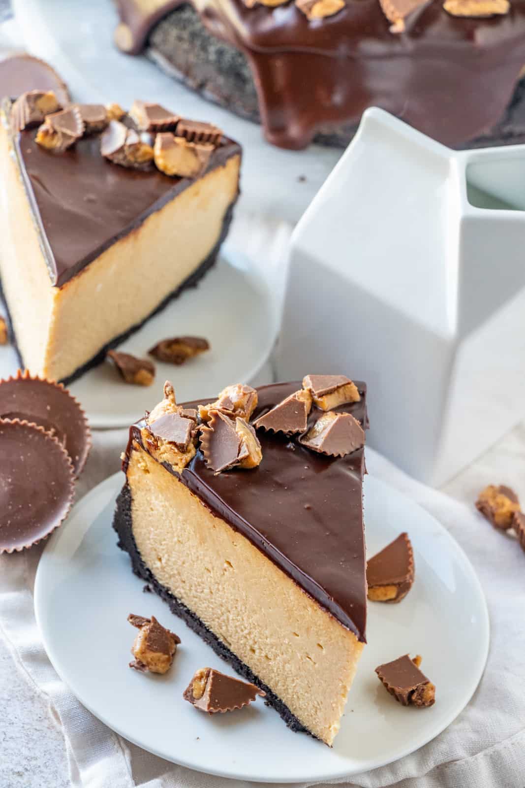 Overhead of two slices of peanut butter cheese cake on white plates