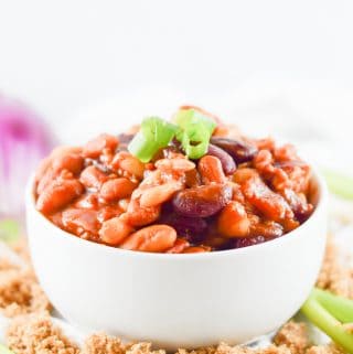 Finished beans in white bowl topped with sliced green onions