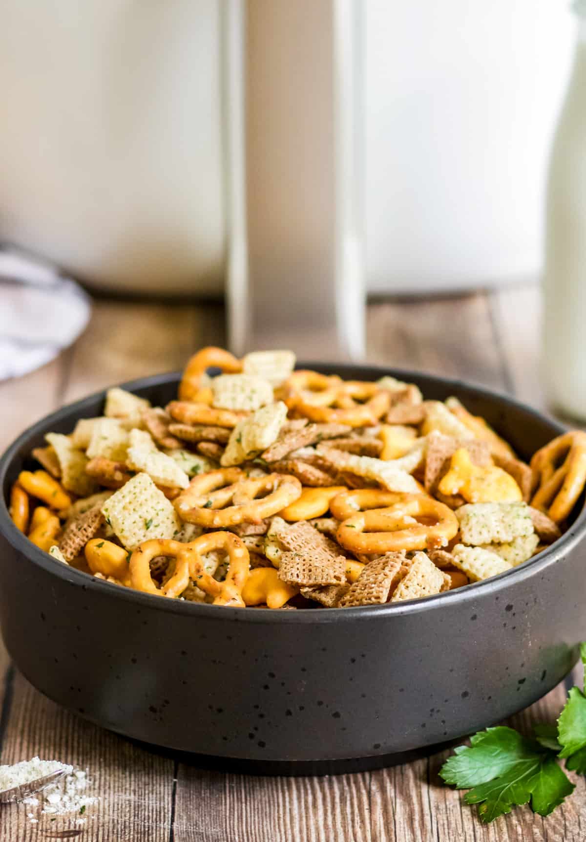 Ranch Chex Mix in black bowl in front of a white air fryer.