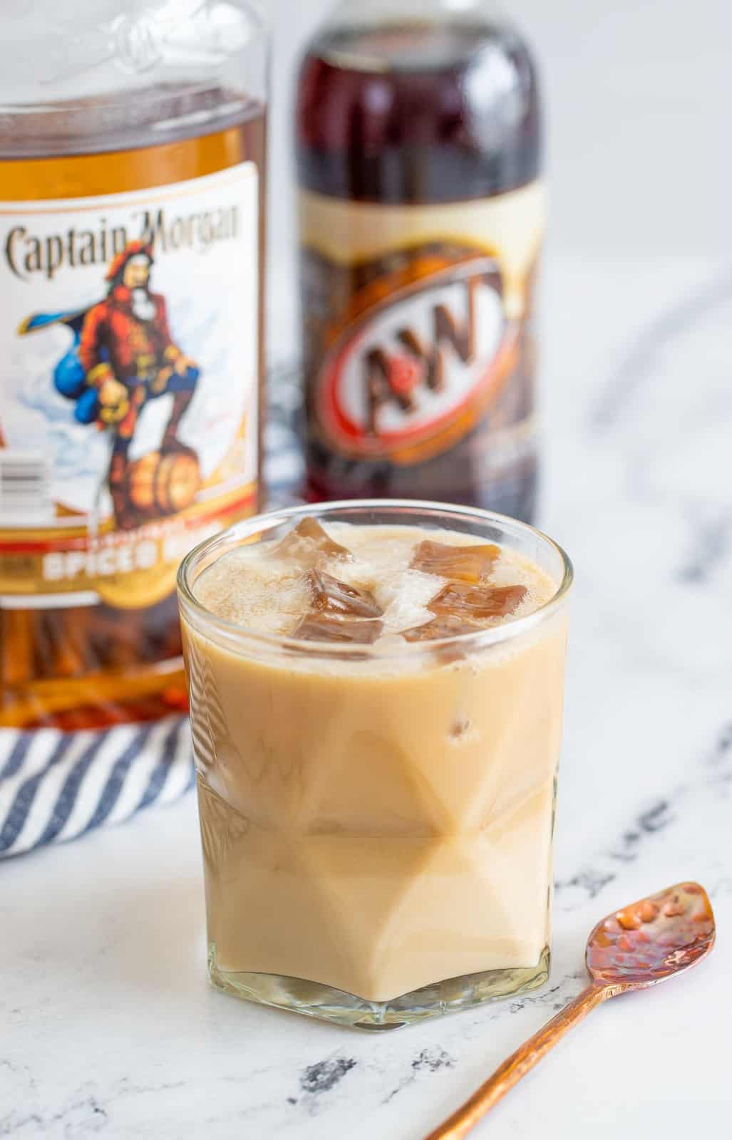 Cocktail in glass with rum and root beer in background