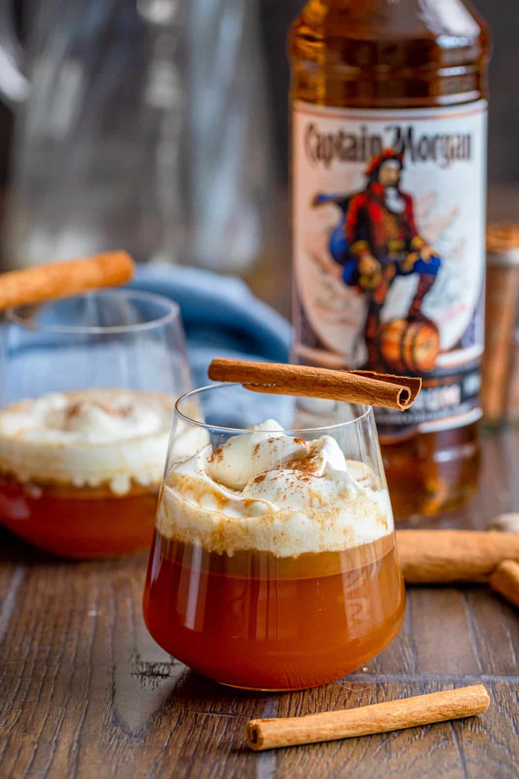 Close up of Hot Buttered Rum in glasses with captain Morgan bottle in background