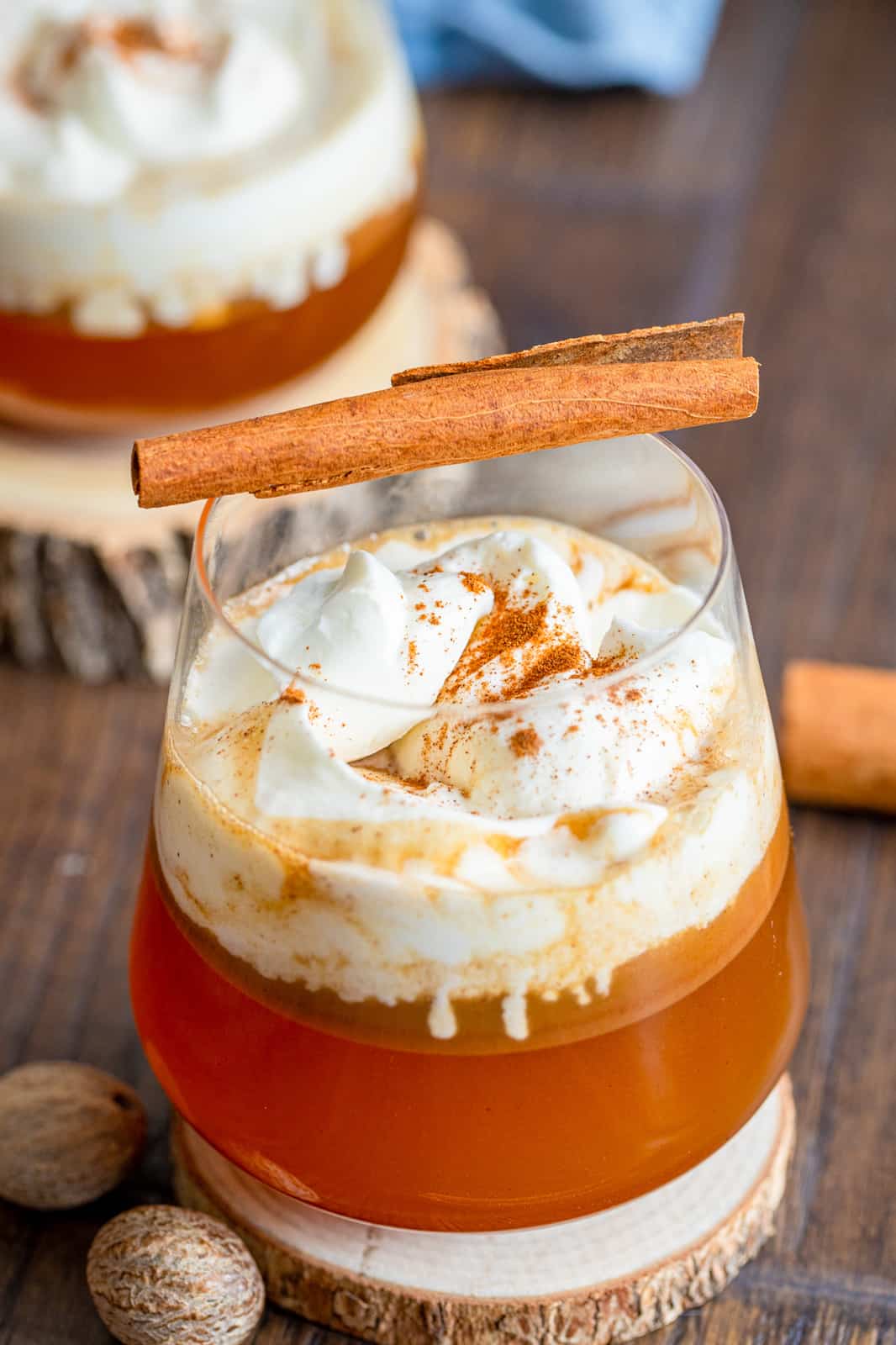 Overhead of hot buttered rum with whipped topping and cinnamon stick